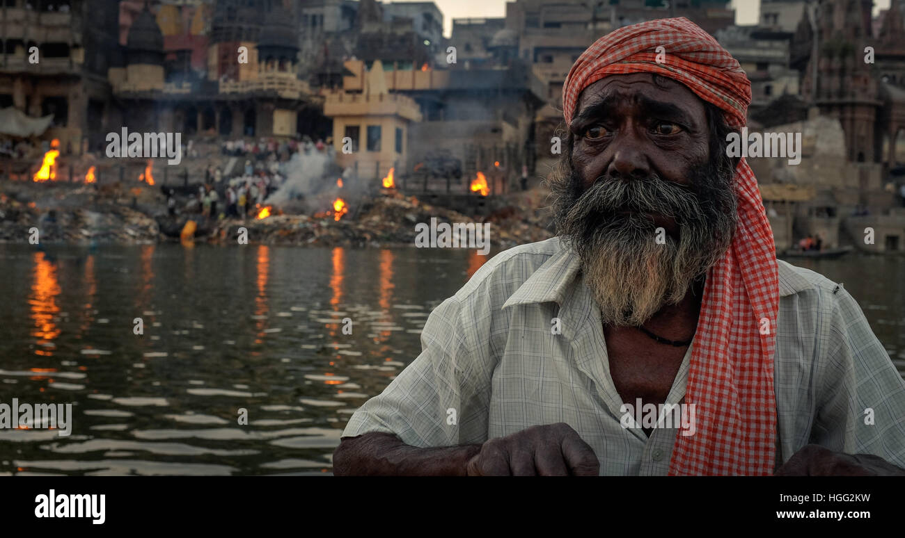 Bootsmann Rudern vor Manikarnika Ghat am Ganges in Varanasi, Indien. Stockfoto