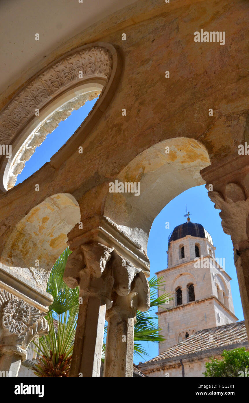 Blick auf Dubrovnik Stadt Glockenturm durch die Bögen des Franziskanerklosters befindet sich auf der Straße. Stockfoto