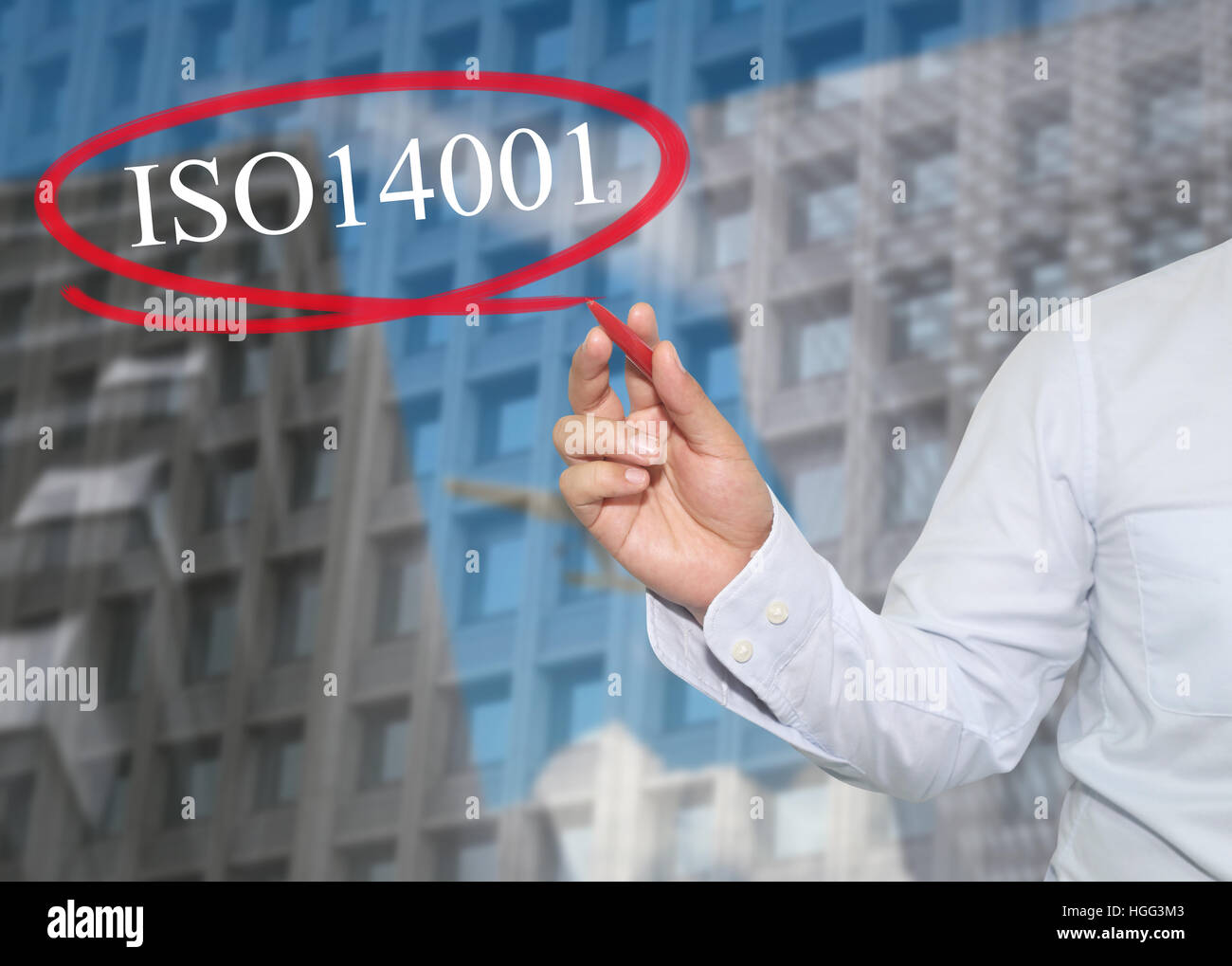 Hand des jungen Geschäftsmann schreiben Sie das Wort ISO 14001 auf Wolkenkratzer Hintergrund, Konzept anwenden, um Ihr Geschäft zu fördern oder Präsentationen zu arbeiten. Stockfoto