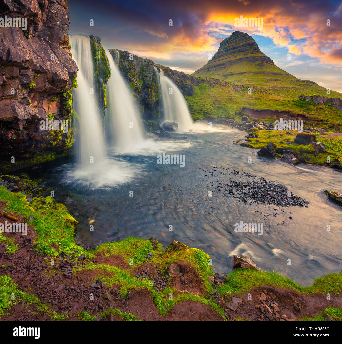 Sommer Sonnenuntergang am berühmten Kirkjufellsfoss Wasserfall und Kirkjufell Berg. Dramatische Abendstimmung auf Snaefellsnes Halbinsel. Stockfoto