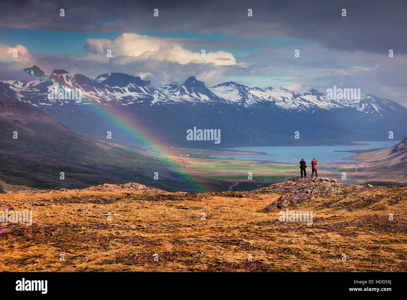 Zwei Fotografen nimmt Bild in einem leichten Regen und Regenbogen in den isländischen Bergen. Bunte Sommermorgen in der Island. Stockfoto