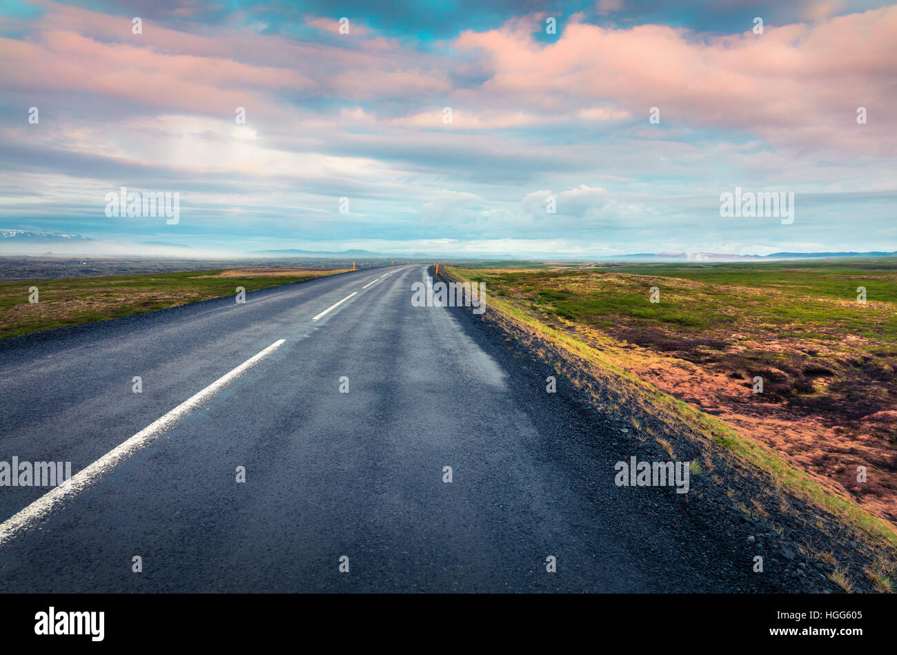 Leere Asphaltstraße mit bunten bewölkten Himmel. Schöne Outdoor-Landschaft in Island, Europa. Foto von Reise-Konzept-Hintergrund Stockfoto
