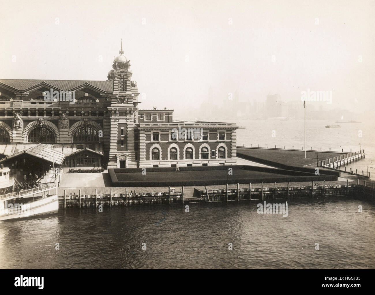 Blick auf Teil der vorderen Fassade der Immigration Station; die Skyline von New York ist kaum erkennbar, durch den Nebel im Hintergrund - Ellis Island Immigration Station 1902-1913 Stockfoto