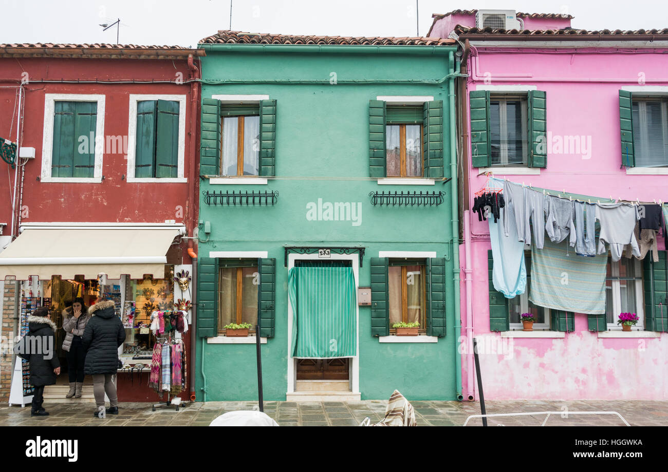 Häuser und eine Ladenfront mit waschen hängen oben in Burano, Venedig, Italien Stockfoto