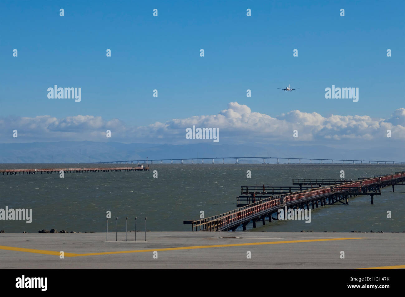 Flugzeug Landung auf dem Flughafen mit blauer Himmel, Wolken und San Mateo Bridge unter Stockfoto