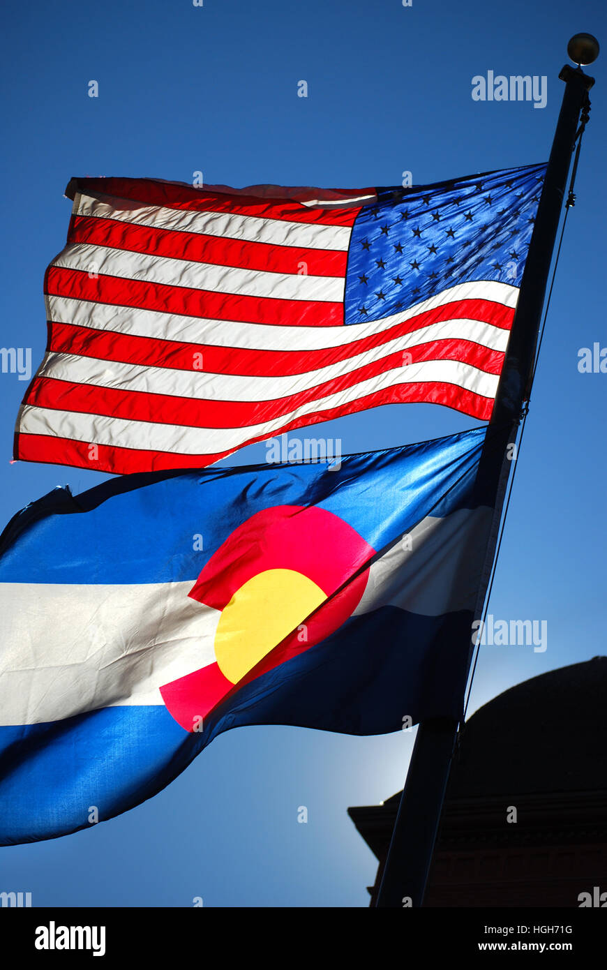 USA und Colorado State Flags fliegen im Wind. Stockfoto