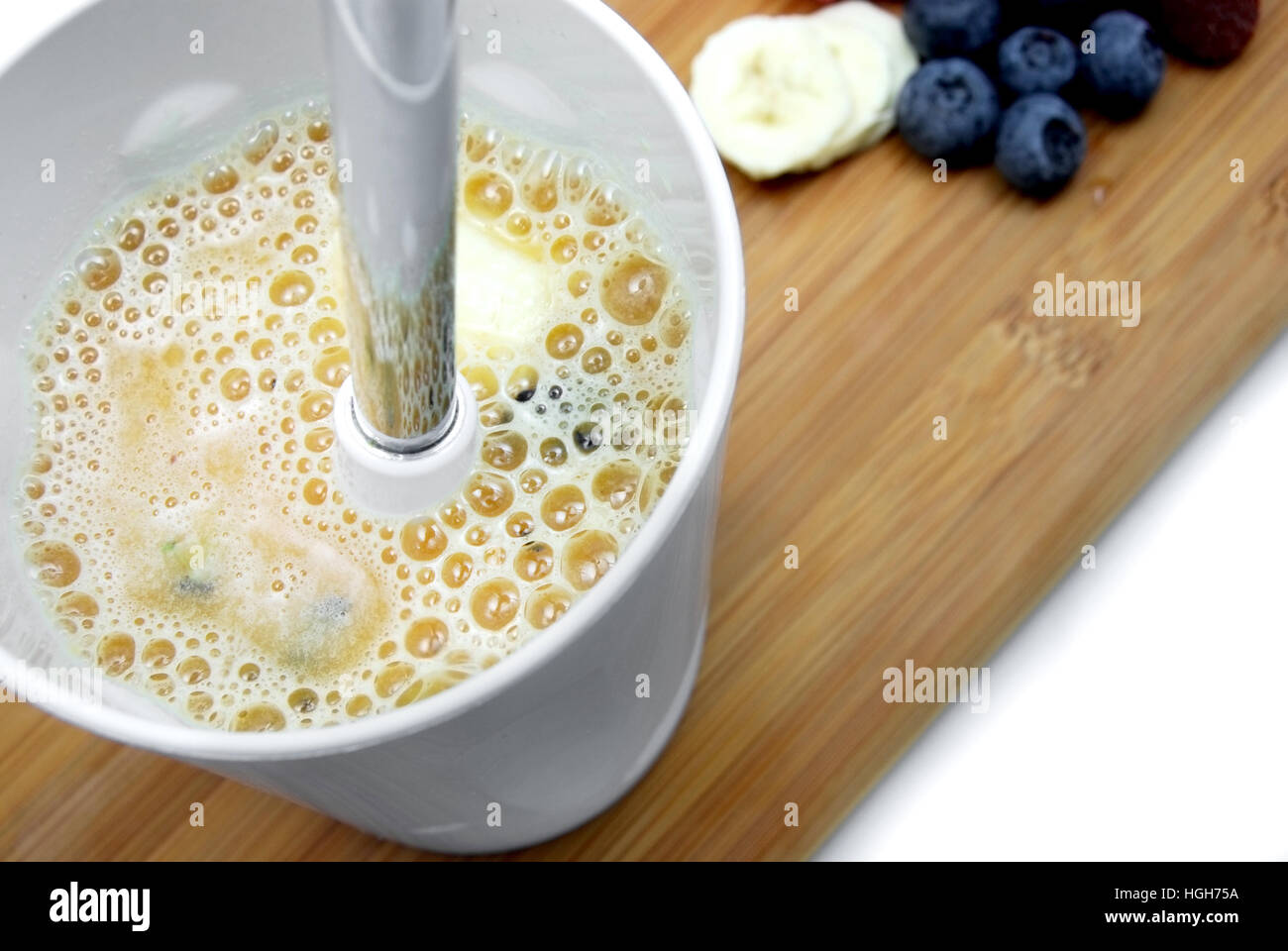 Mischen einen Smoothie. Erhöhte Ansicht mit Banane und Heidelbeere Frucht im Hintergrund. Stockfoto