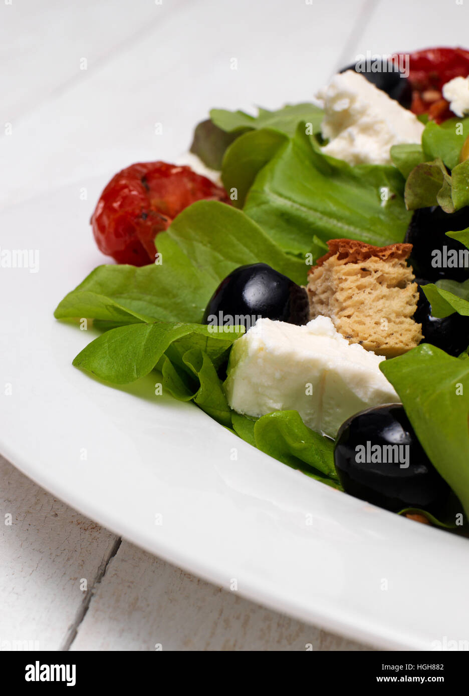 Frischer grüner Salat mit Kunststück Käse und schwarzen Oliven Stockfoto