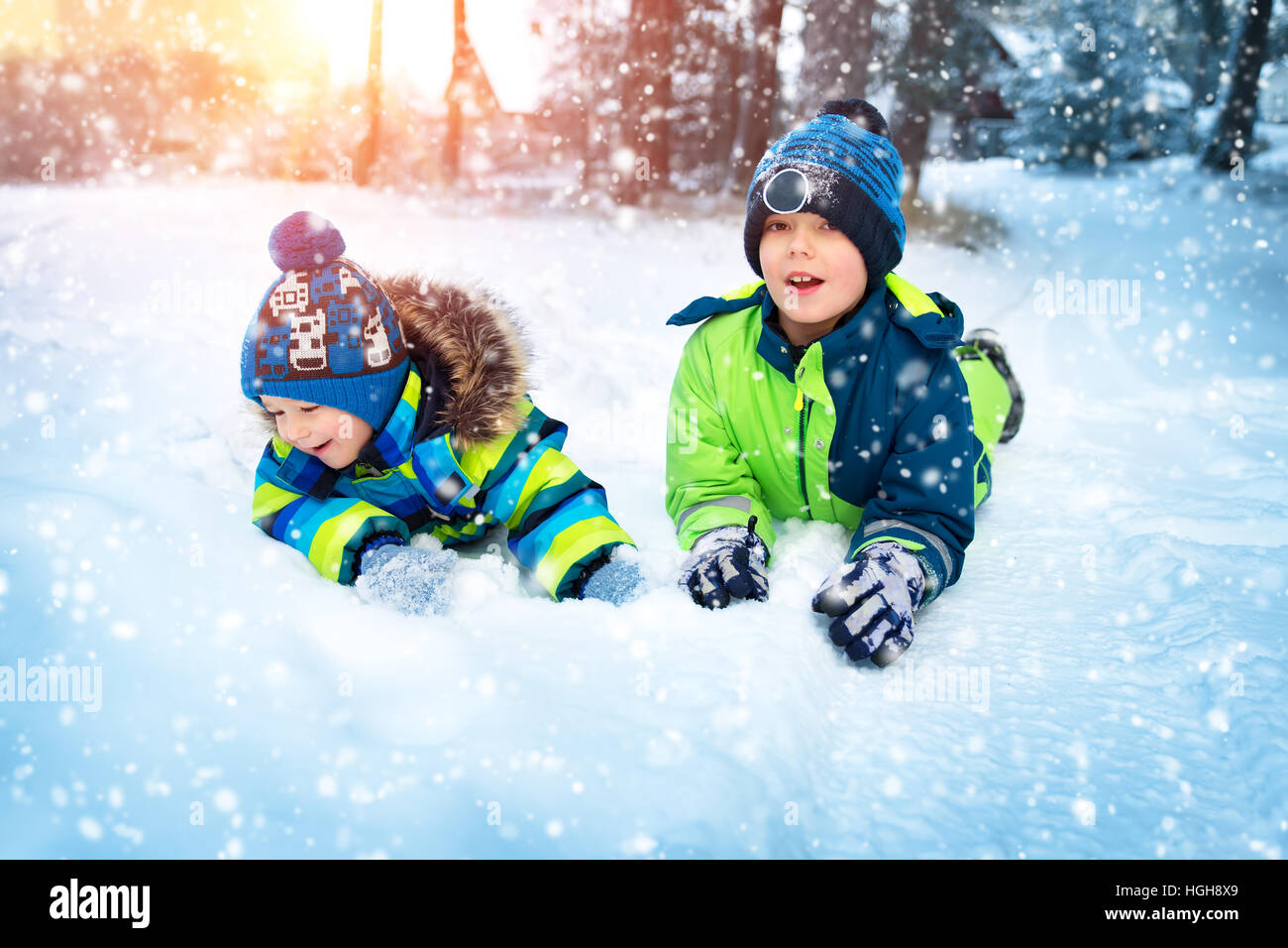 Kinder spielen im Schnee bei Schneefall Stockfoto