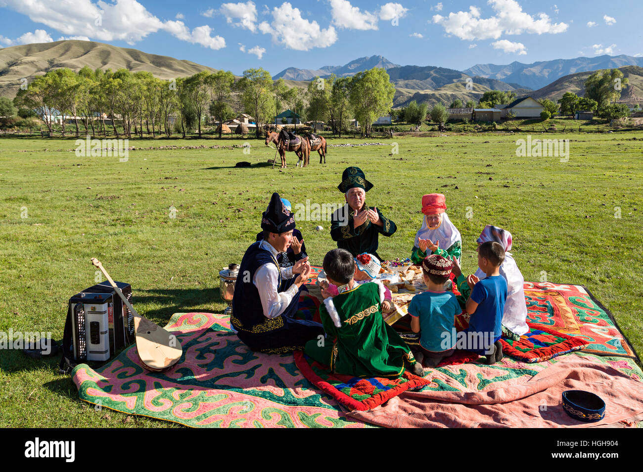 Kasachische Familie beten alle zusammen, bevor sie beginnen, ihre Picknick-Mittagessen. Stockfoto