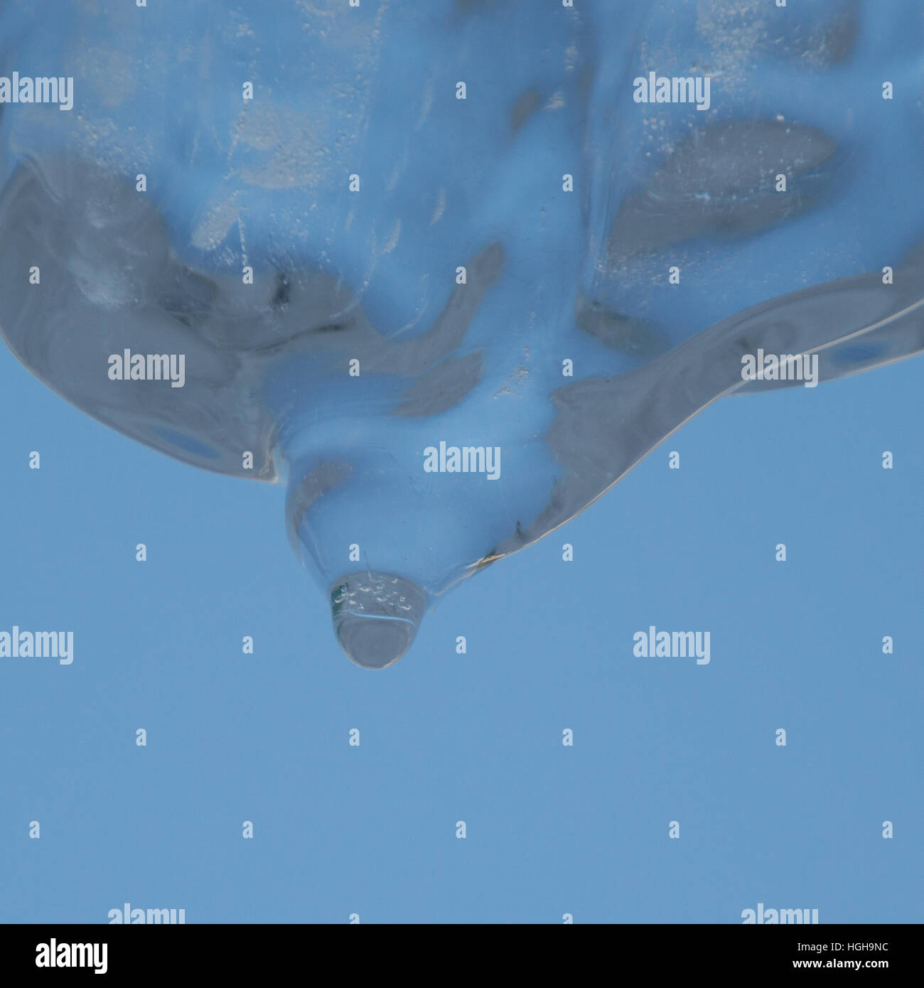 Abstraktes Bild der himmelblauen Hintergrund und blickte zu einer breiten kristallklare Eiszapfen schmelzen und Tropfwasser. Stockfoto