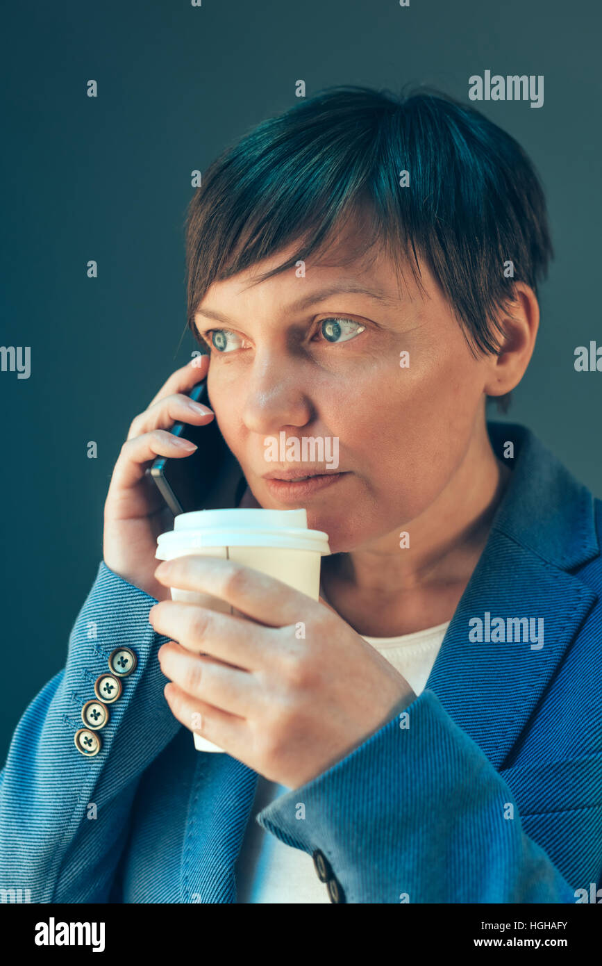 Junge Erwachsene Geschäftsfrau Kaffeetrinken gehen und telefonieren mit Handy Stockfoto