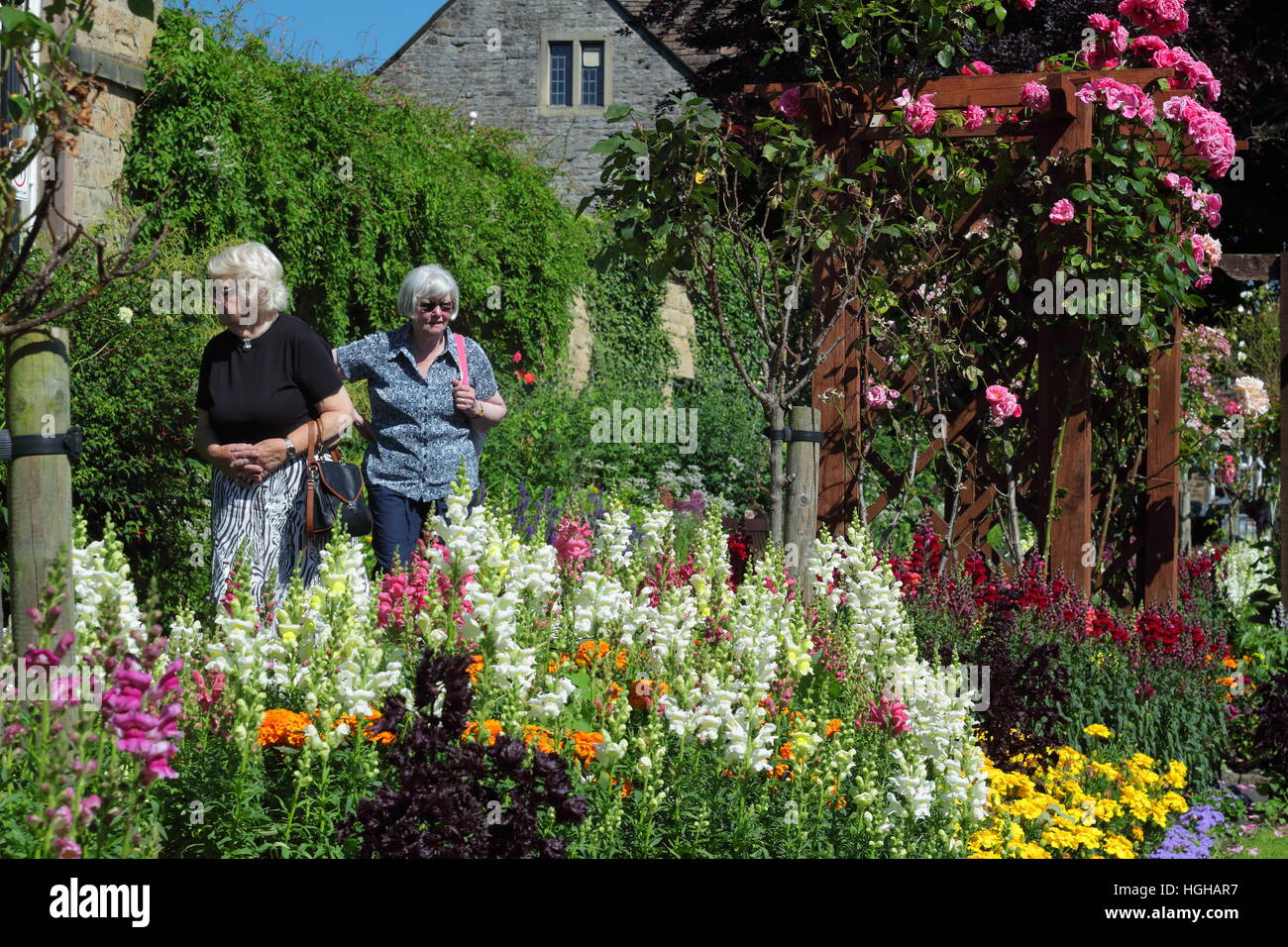 Besucher zum Bad Garten; eine öffentliche Grünfläche in Bakewell, Derbyshire bewundern die herrliche Sommer Blumenrabatten in dieser Peak District Marktstadt Stockfoto