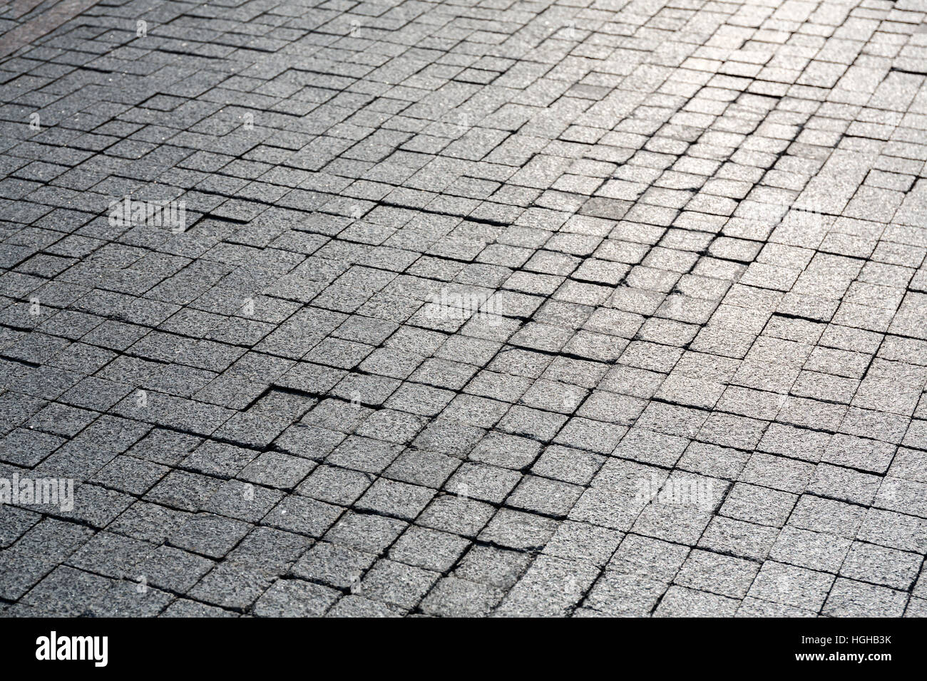 Granit Pflasterstein Pflaster Hintergrund mit Sonnenschein Reflexion Stockfoto