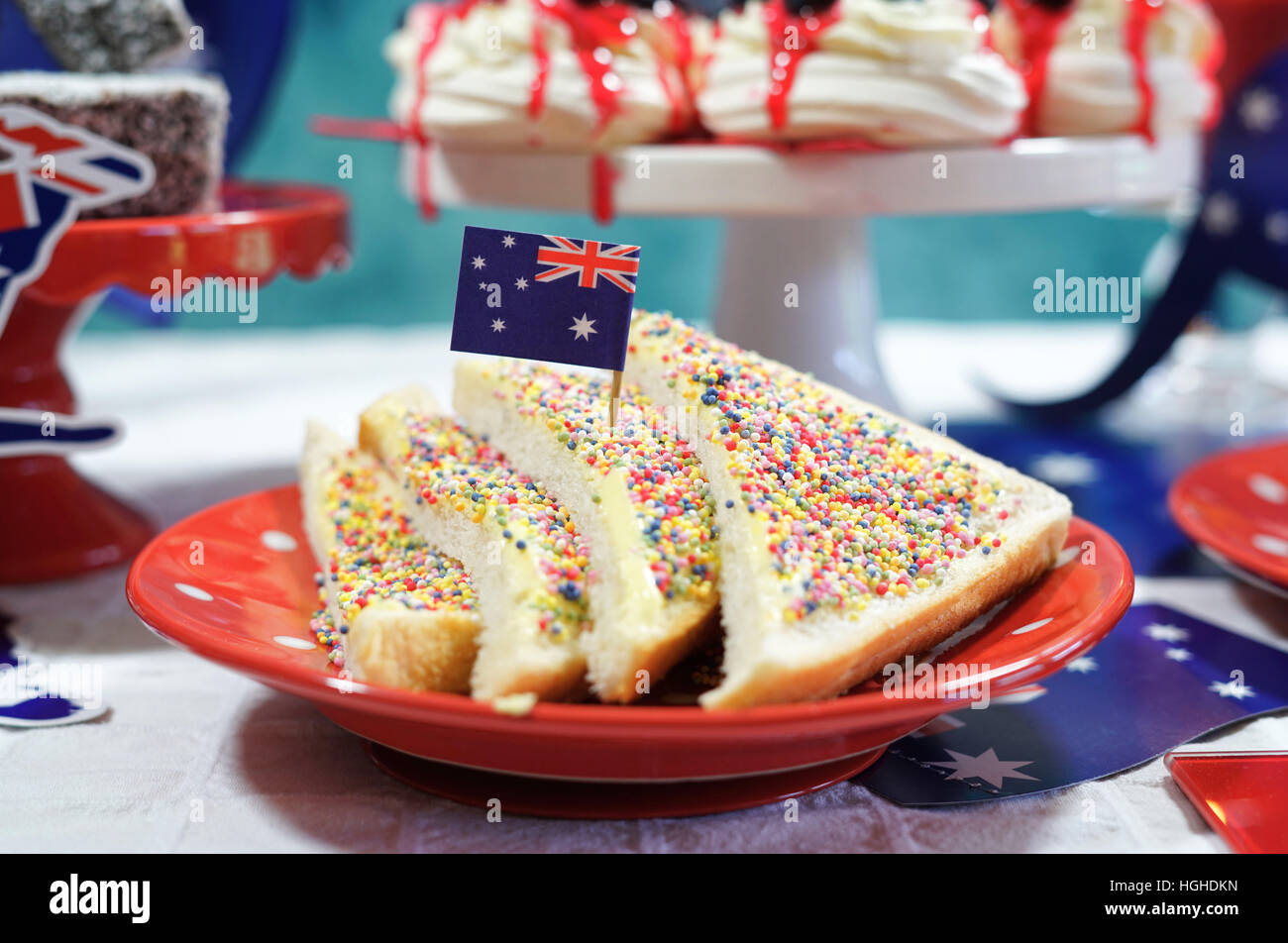 Australische Thema Party Tisch mit Fahnen und ikonischen Lebensmittel einschließlich Mini Dreimast, Lamingtons, Fleischpasteten und Fee Brot. Stockfoto