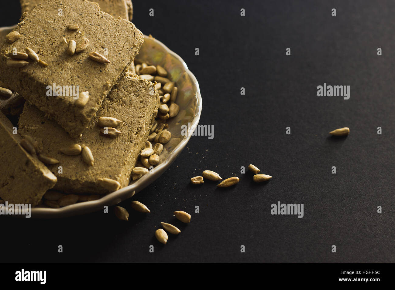 Sonnenblume Halva mit Samen auf Platte, auf schwarzem Hintergrund Stockfoto