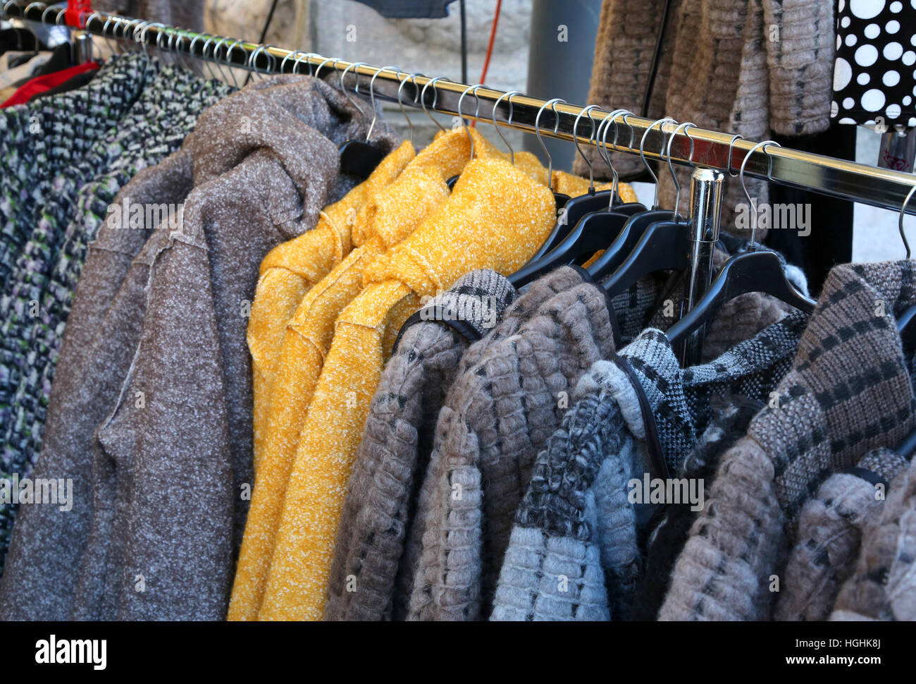 Gebrauchte Kleidung und viele Winterkleidung hing auf Kleiderbügeln zum Verkauf auf dem Flohmarkt Stockfoto