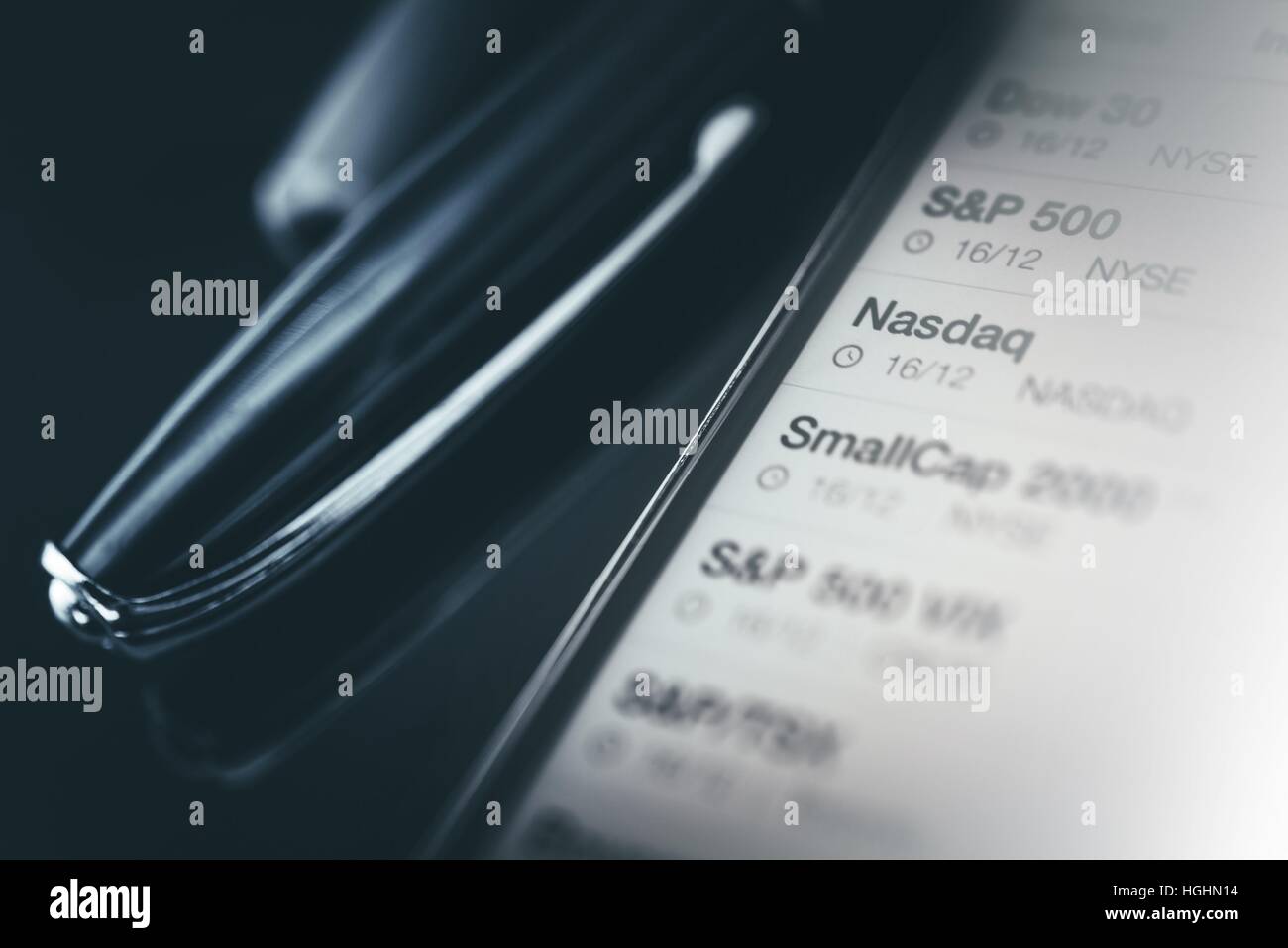 Stock Market Trader Schreibtisch Konzept. Marco Photo Smartphone anzeigen Börse Daten und eleganten Füllfederhalter auf dunklen gläsernen Schreibtisch. Stockfoto