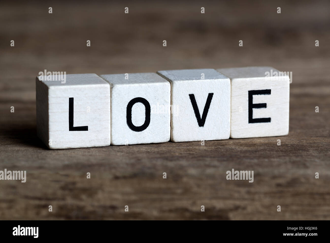 Liebe, geschrieben in Würfeln auf hölzernen Hintergrund Stockfoto