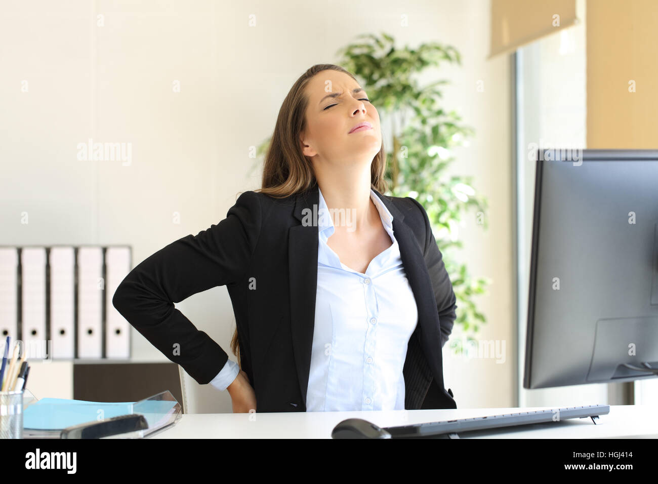 Unglückliche Geschäftsfrau leiden Rückenschmerzen sitzen auf einem unbequemen Sitz am Arbeitsplatz Zuhause in ihrem Büro Stockfoto