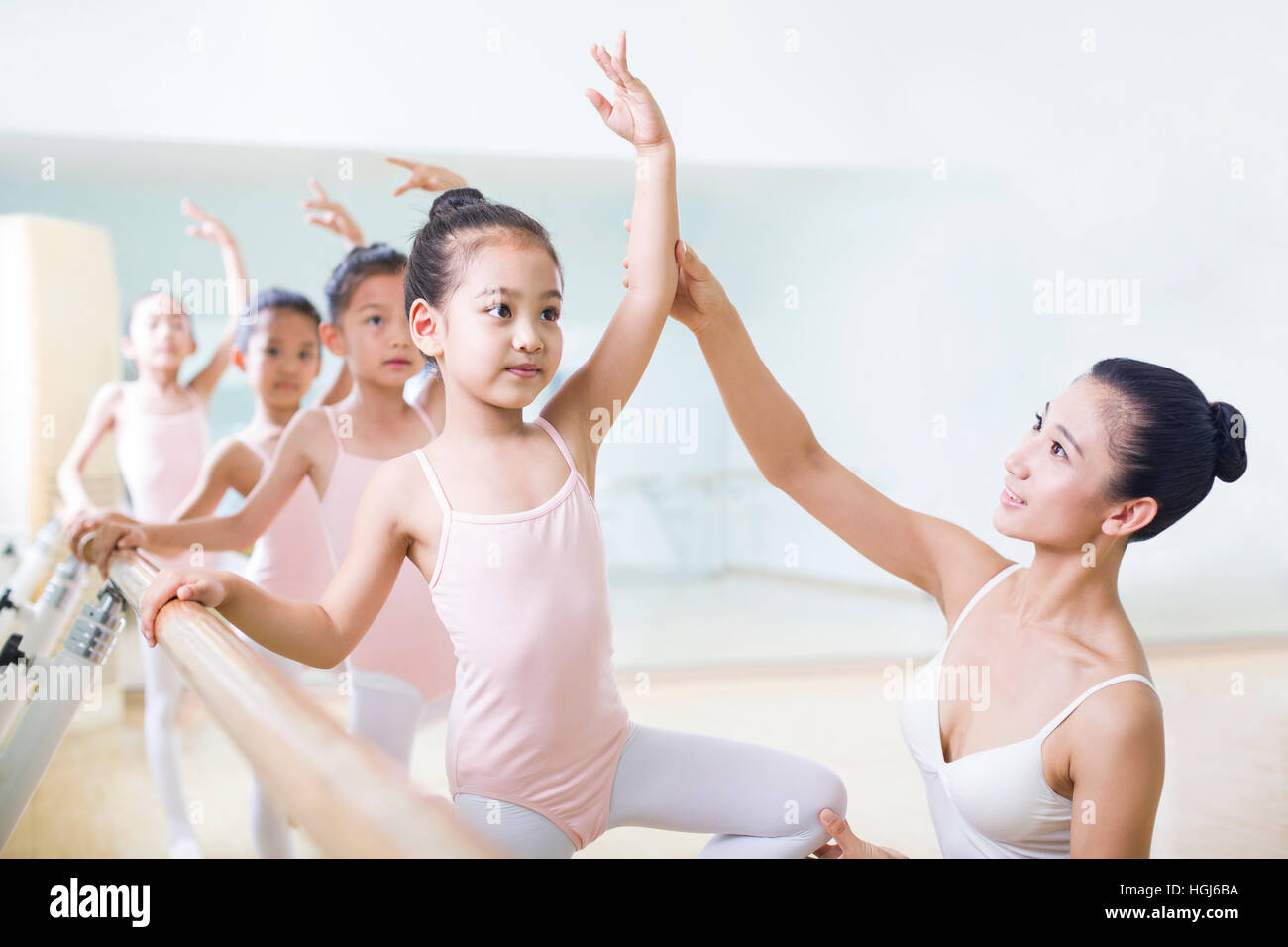 Junge Ballett Lehrer unterrichten Mädchen im Ballettstudio Stockfoto
