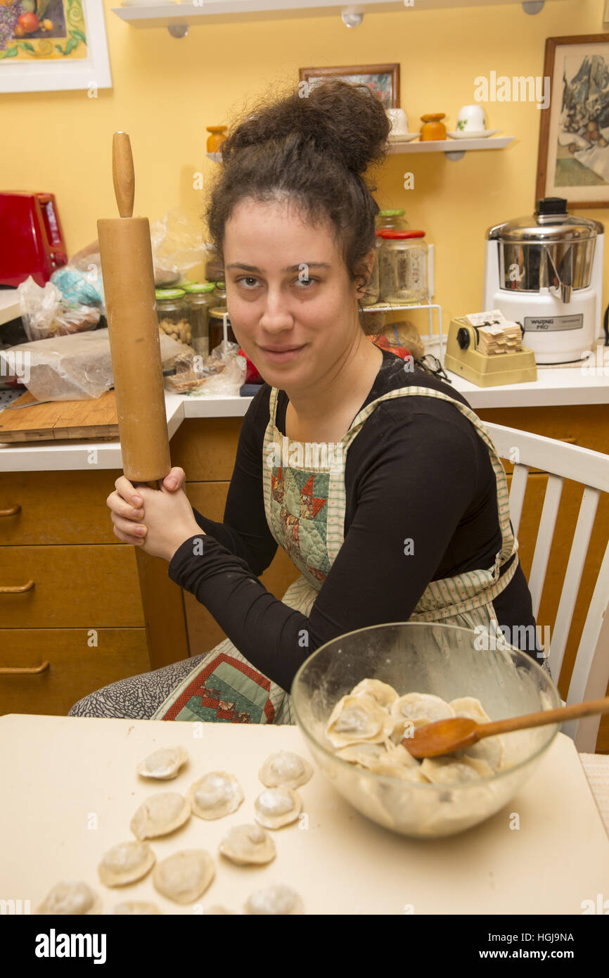 Junge Frau posiert mit ihr Nudelholz und Pierogi (polnische Klöße) für ein traditionelles Weihnachtsessen in Brooklyn, NY. Stockfoto