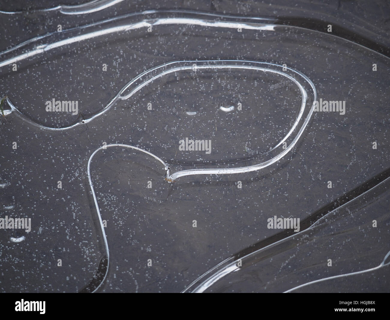 Muster des Eises in gefrorenen Pfütze vor Kopf der Figur mit Details Silber Blasen-und Schmelzwasser Stockfoto