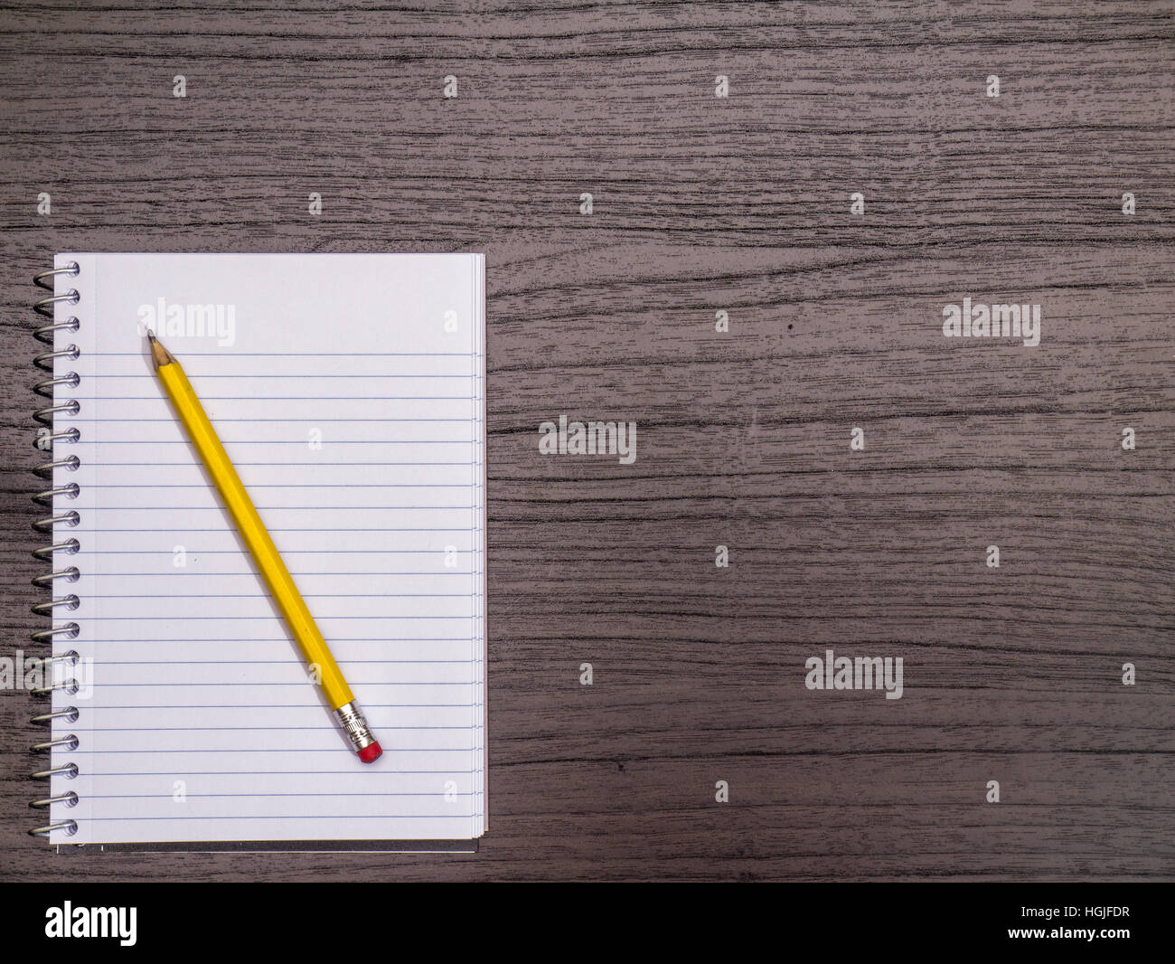 Dunkles Holz Schreibtisch, Spiralblock, Bleistift Stockfoto