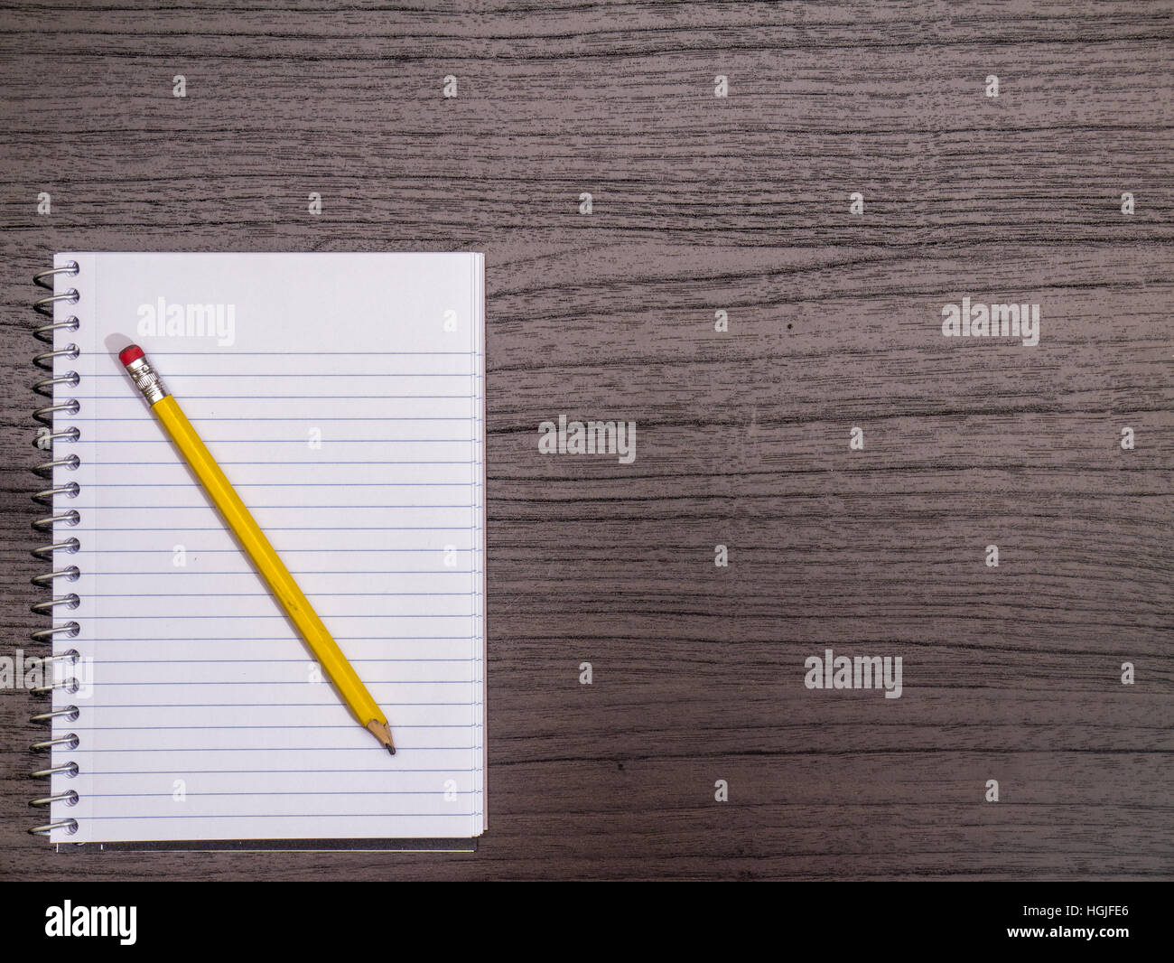 Dunkles Holz Schreibtisch, Spiralblock, Bleistift Stockfoto