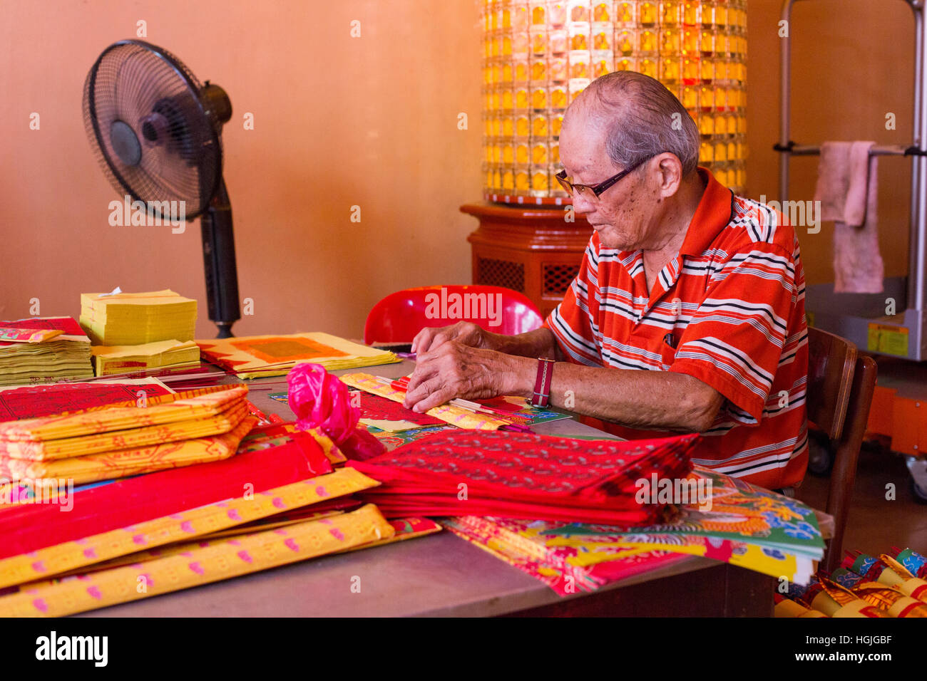 Ein chinesischer Mann bereitet Angebote Bundles in Vorbereitung für das chinesische Neujahrsfest. Stockfoto