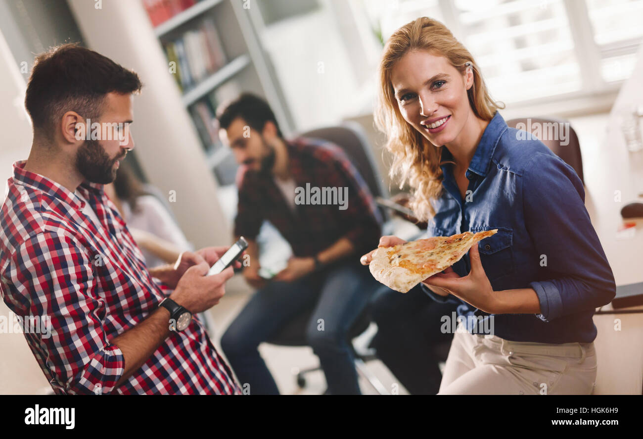 Kollegen Essen Pizza während der Arbeit im Büro zu brechen Stockfoto