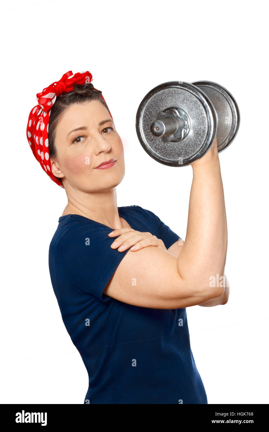 Stolze Frau mit roten Halstuch und blaues T-shirt heben eine schwere Hantel, isoliert vor weißem Hintergrund, Rosie Riveter Stockfoto