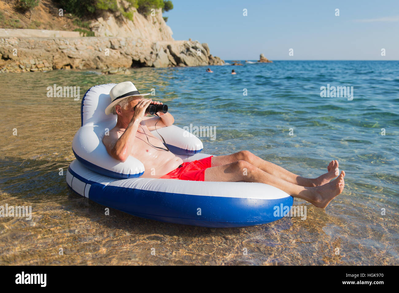 Ältere Mann mit Spion Brille auf Stuhl im Meer schwimmen Stockfoto