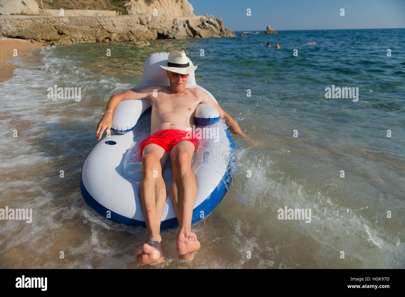 Ältere Mann im Urlaub auf Stuhl im Meer schwimmen Stockfoto