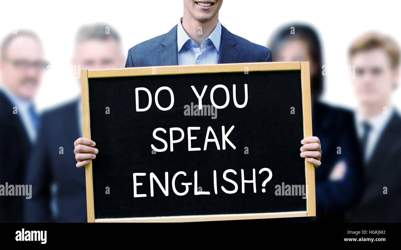 junger Geschäftsmann mit einem Schild mit den Worten tun Sie Speak English und Gruppe von Menschen, die hinter ihm Stockfoto