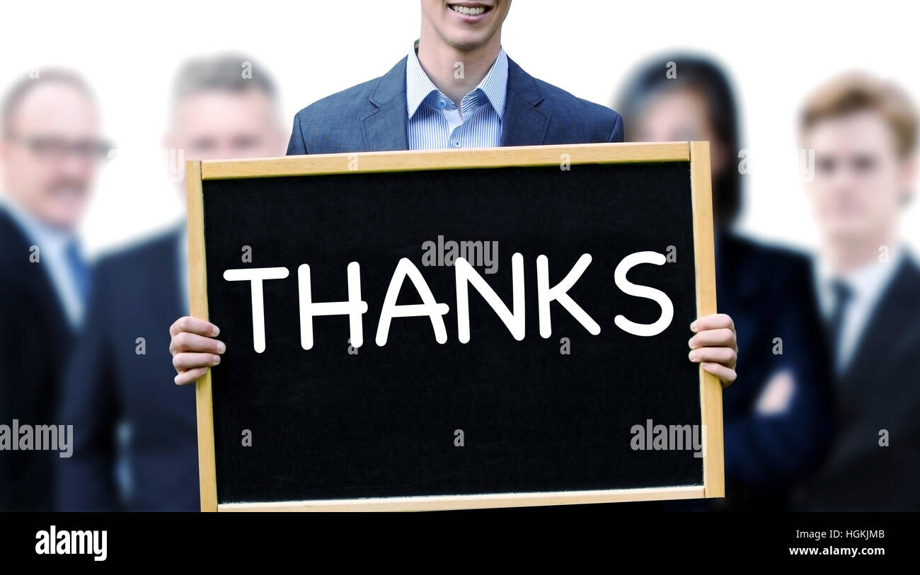 junger Geschäftsmann mit einem Schild mit dem Wort Danke und Gruppe von Menschen, die hinter ihm Stockfoto