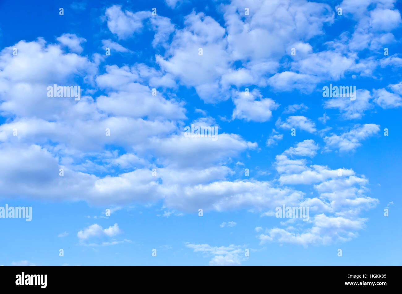 Vereinzelten weißen Cumulus-Wolken in ein strahlend blauer Himmel Stockfoto