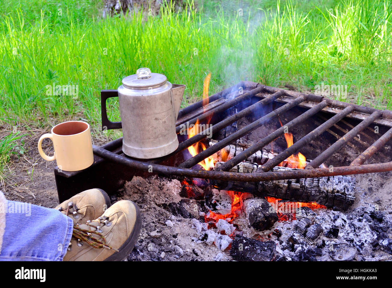 Füße auf ein Lagerfeuer warten auf den Kaffee Perk Stockfoto