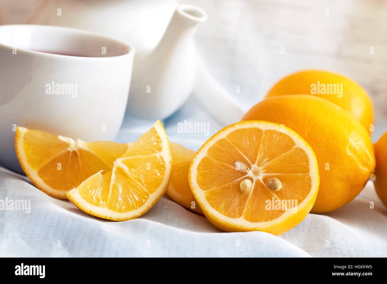 Zitrone mit Tasse Tee und Teekanne im Hintergrund Stockfoto