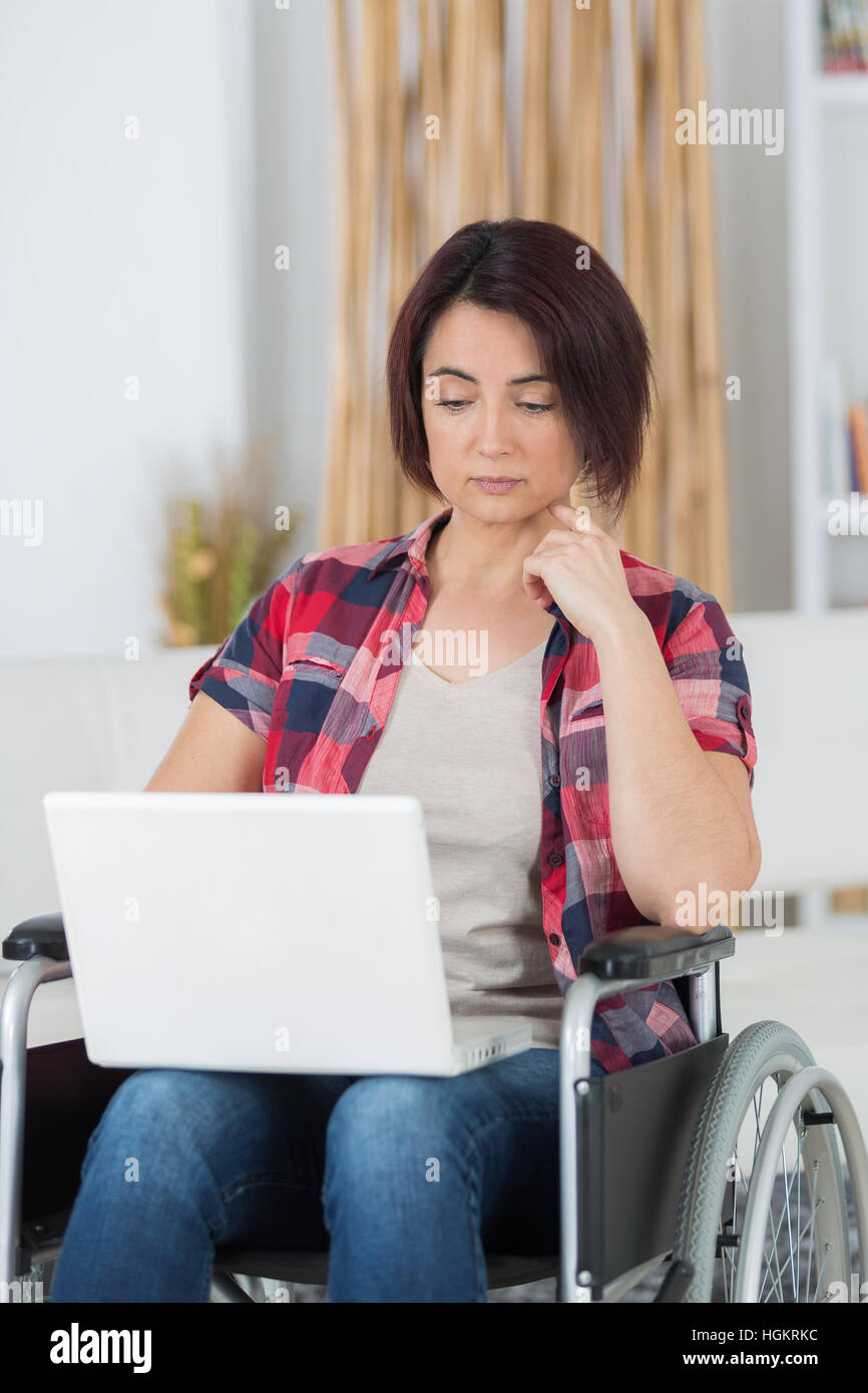 behinderte Frau, die im Web Surfen Stockfoto
