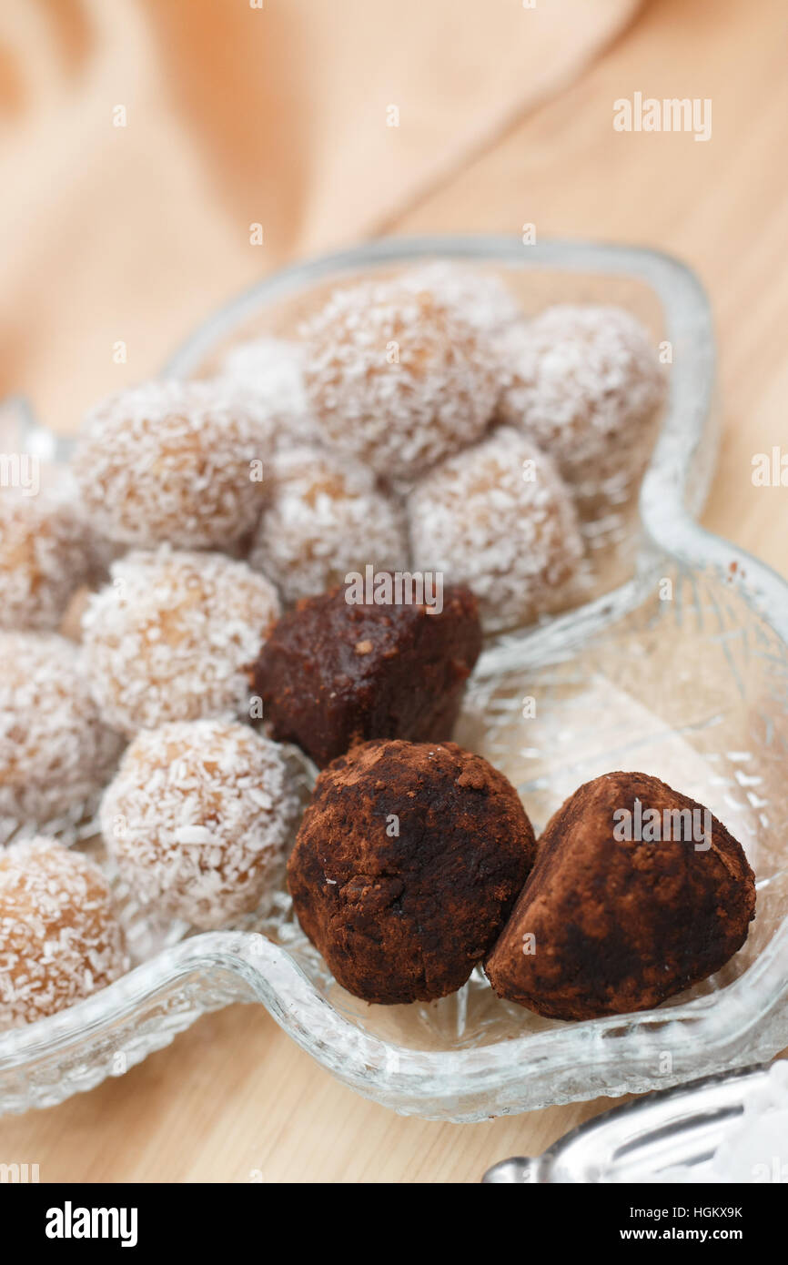 Trüffel und Schokokugeln mit Kokosnuss Flocken Schuss bei künstlichem Licht Stockfoto