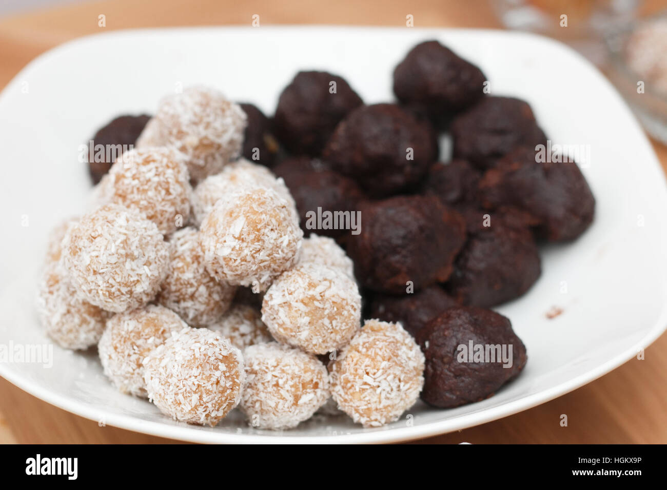 Trüffel und Schokokugeln mit Kokosnuss Flocken Schuss bei künstlichem Licht Stockfoto