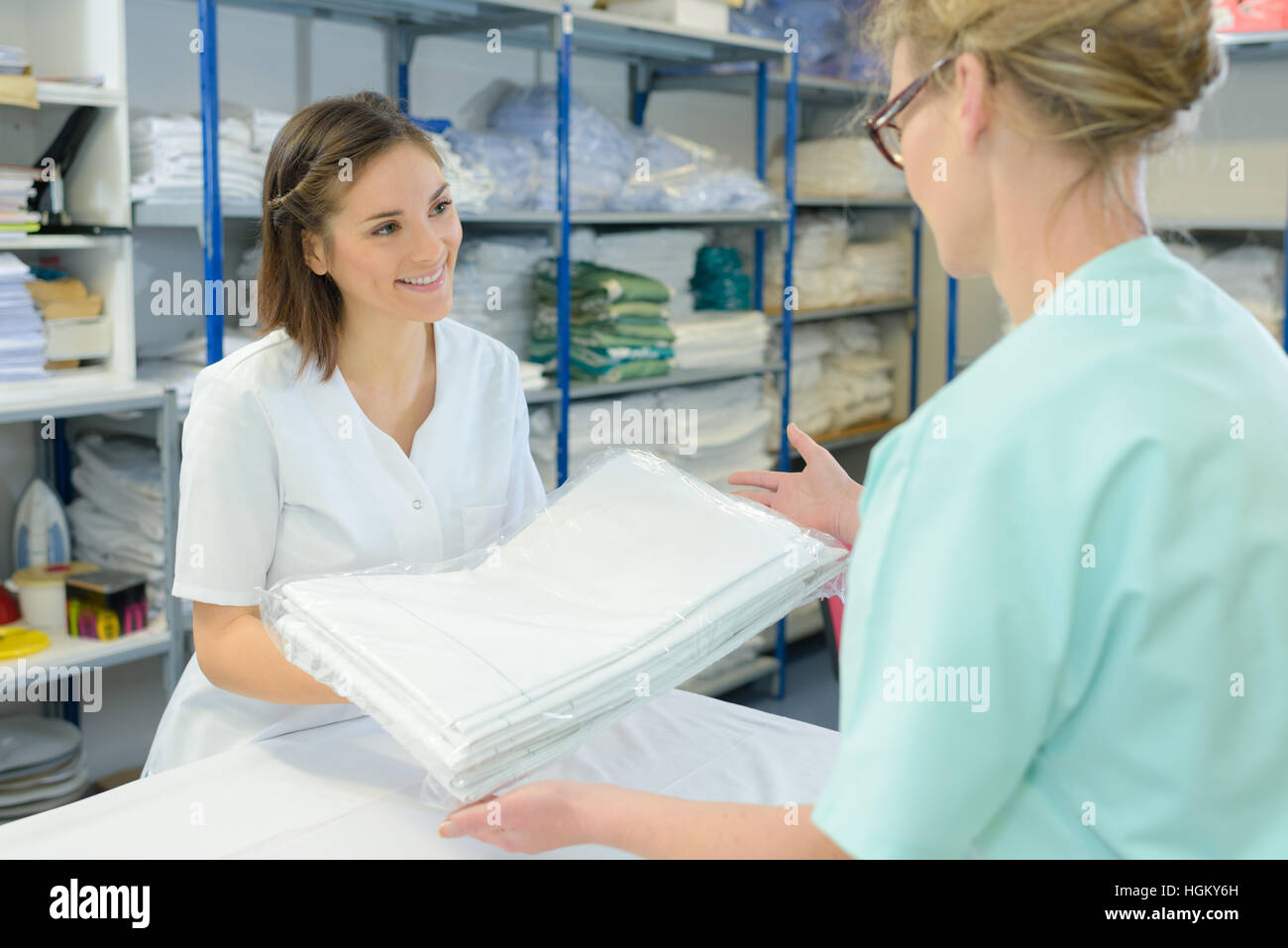 Krankenschwester mit sauberen Laken von Krankenhauswäsche Stockfoto