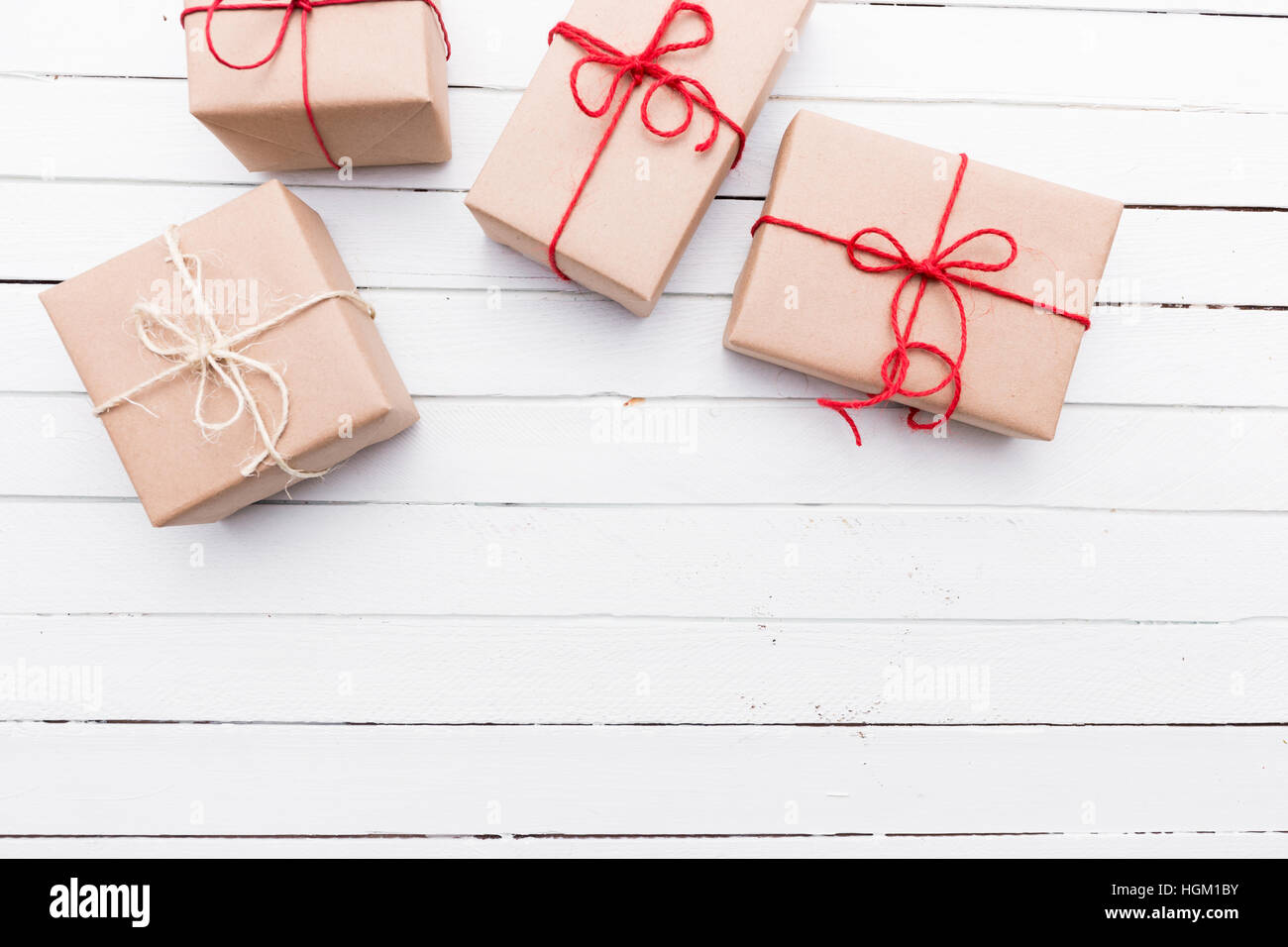 Weihnachtspaket Stil rustikal braun Papier gefesselt mit Streichern. Weiße Holz Hintergrund. Stockfoto