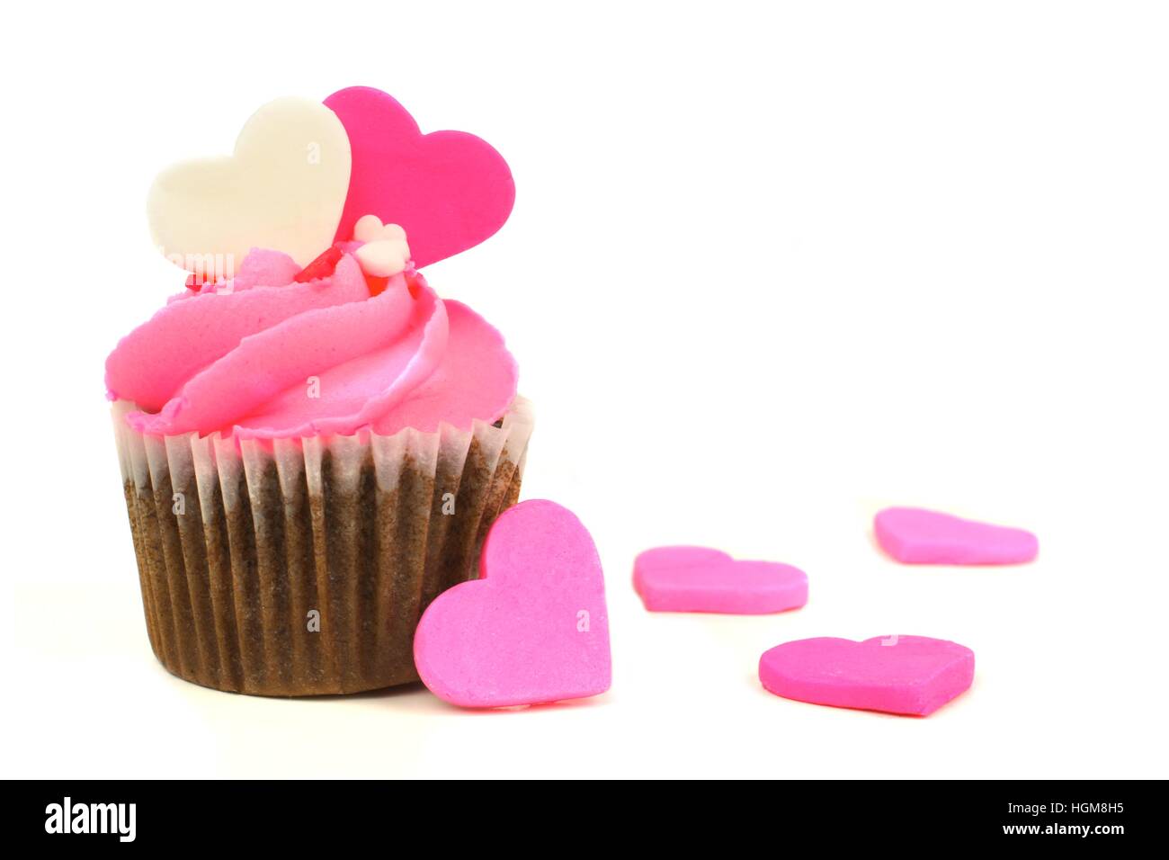 Schokolade Valentinstag Cupcake mit rosa Zuckerguss und Herzen über einen weißen Hintergrund Stockfoto