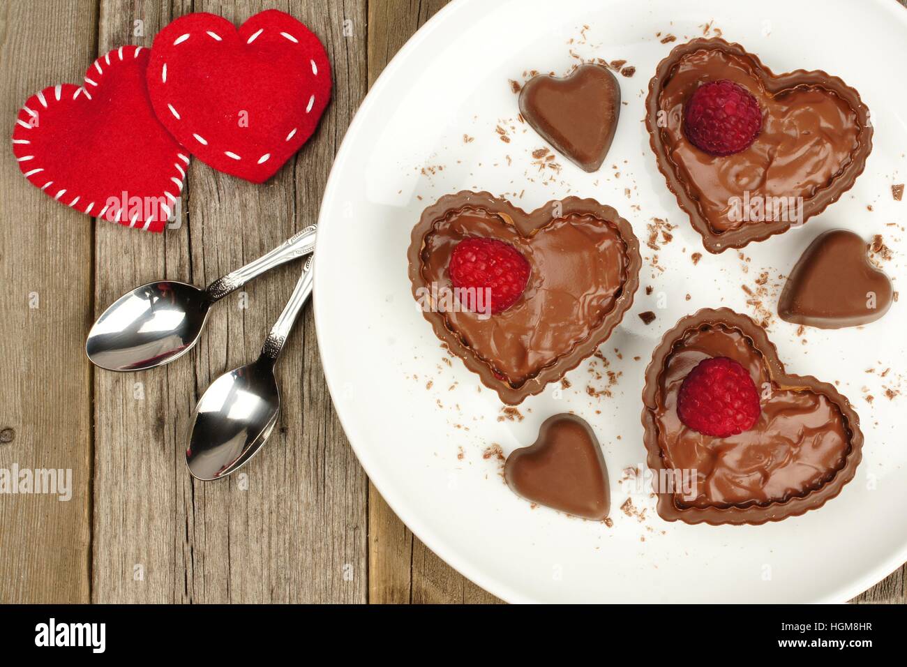 Herzförmige Schokoladendessert Tassen-Pudding mit Himbeeren auf Teller mit Holz Hintergrund Stockfoto