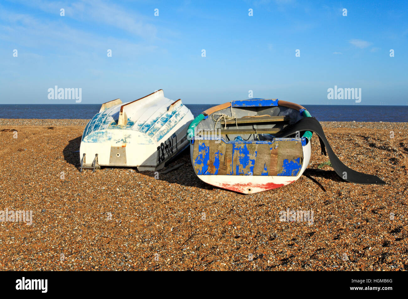 Zwei kleine Boote, einen aufrechten und ein umgeworfen, am Strand von Cley nächstes Meer, Norfolk, England, Vereinigtes Königreich. Stockfoto