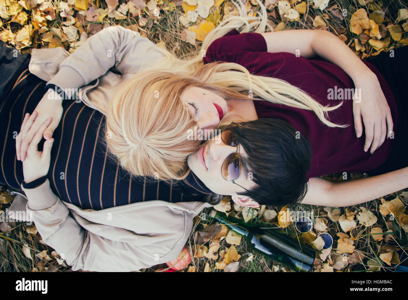 Junges Paar liegt auf dem Boden in einem Park im Herbst Stockfoto