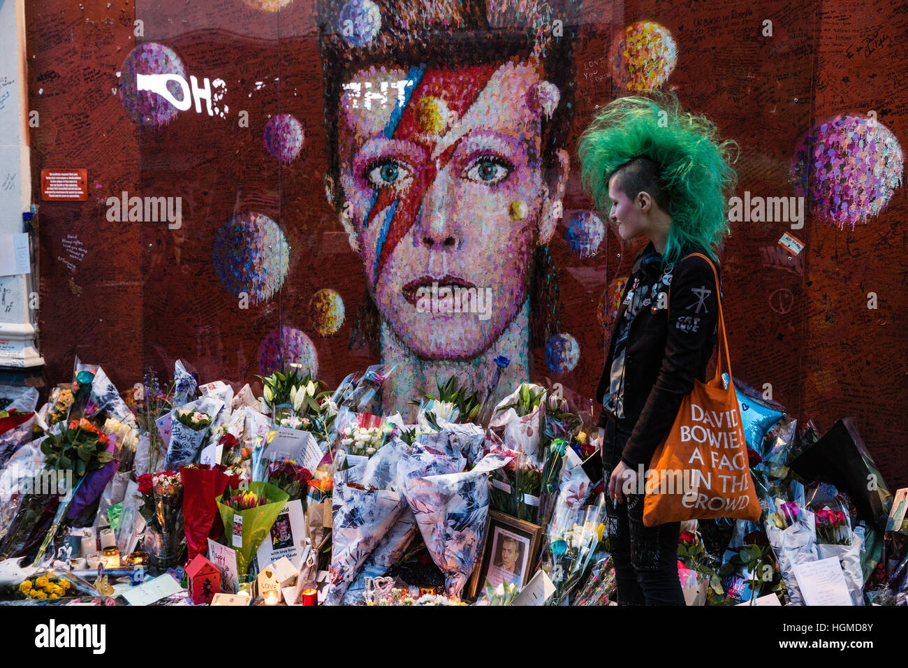 London, UK. 10. Januar 2017.  Eine Mädchen mit einem grünen Mohikaner Haarschnitt ist eine Hommage an David Bowie vor einem Wandgemälde in Brixton am ersten Jahrestag seines Todes. Bildnachweis: Mark Kerrison/Alamy Live-Nachrichten Stockfoto