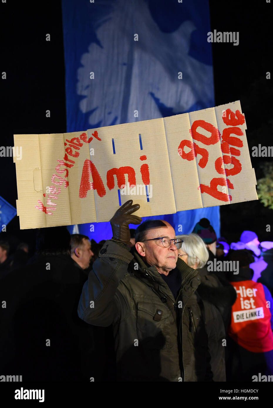 Ein Demonstrant hält ein Plakat, auf dem die Worte "Ami [d.h. amerikanischen] nach Hause gehen" während einer Protestaktion organisiert, von linksgerichteten Aktivisten in Brandenburg, Deutschland, 9. Januar 2017. Rund 40 US-Militärfahrzeuge und 120 Soldaten sollen im Bereich für die Nacht bleiben wie sie ihren Weg nach Osten in Richtung der russischen Grenze rund 4.000 US-Soldaten bereitgestellt werden, im Rahmen der Operation Atlantic zu beheben, eine militärische Strategie zur Stärkung der Nato osteuropäischen Mitgliedstaaten und Russland innerhalb ihrer eigenen Grenzen enthalten. Foto: Ralf Hirschberger/Dpa-Zentralbild/dpa Stockfoto